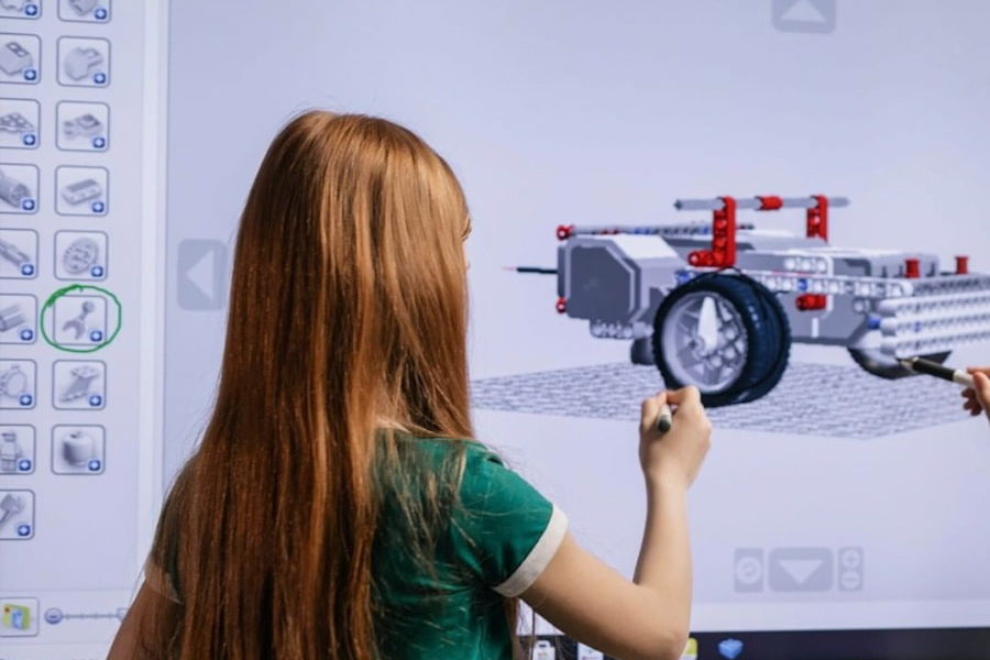 Niña utilizando una pantalla LED con el objetivo de aprovechar al máximo la experiencia interactiva en el evento en el que está..