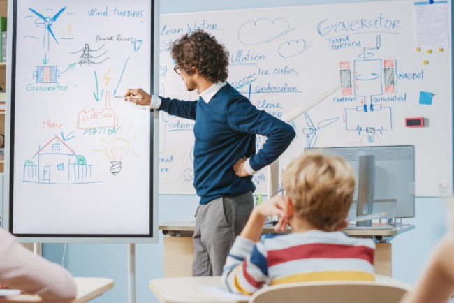 Profesor dando clase con una smart board para favorecer el aprendizaje interactivo.
