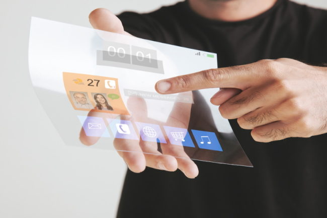 Hombre señalando la información mostrada en una pantalla transparente que sostiene con la mano derecha.