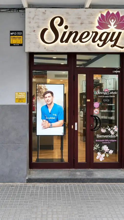 Pantalla profesional vertical integrada en el escaparate de Sinergy Esthetic en El Prat de Llobregat